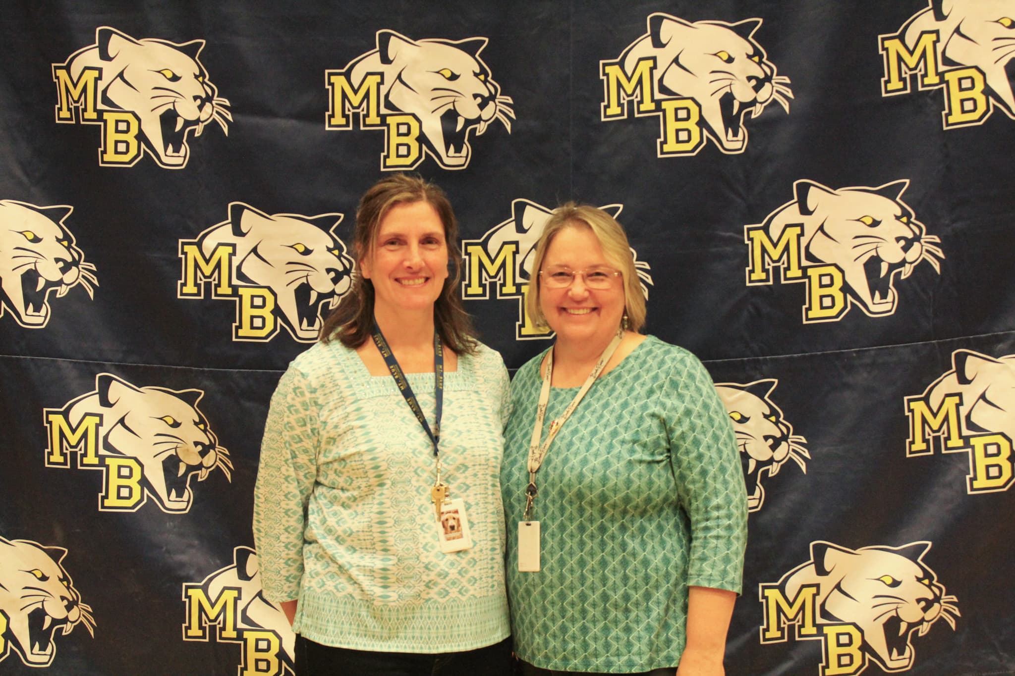 Two women posing in front of a Mt. Blue backdrop